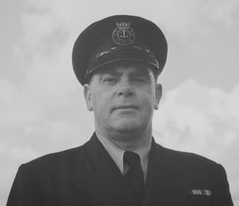 Portrait of Stanley in his fisheries uniform and cap with an anchor insignia CSIA Fisheries.