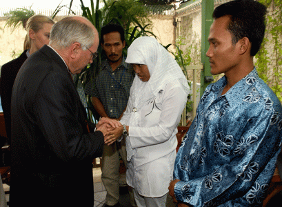 Survivors and victims of the Australian Embassy bombing look on as Prime Minister John Howard comforts a woman whose husband died in the attack, Jakarta, October 2004. NAA: A14482, 040535DI-036. AUSPIC photographer: Michael Jones © Commonwealth of Australia, 2004