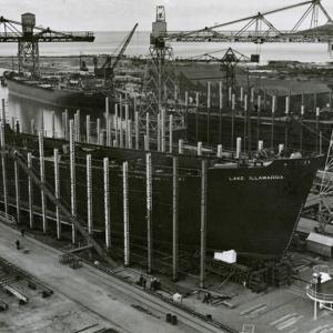 The Lake Illawarra in dry dock surrounded by 2 towering cranes.