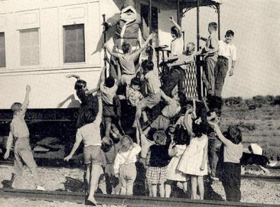 Children gathered around Santa on a train.